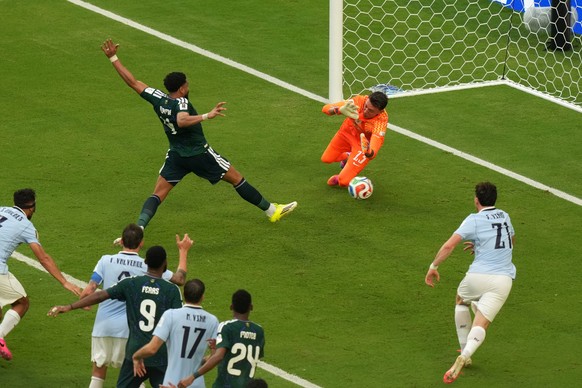 Saudi Arabia's Abdulelah Alamri (4) shoots and scores their opening goal against Uruguay goalkeeper Fernando Muslera (23) during the World Cup Group H soccer match between Saudi Arabia and Urugua ...
