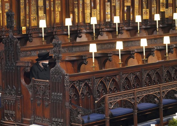 Britain&#039;s Queen Elizabeth II sits alone in St. George&#039;s Chapel during the funeral of Prince Philip, the man who had been by her side for 73 years, at Windsor Castle, Windsor, England, Saturd ...