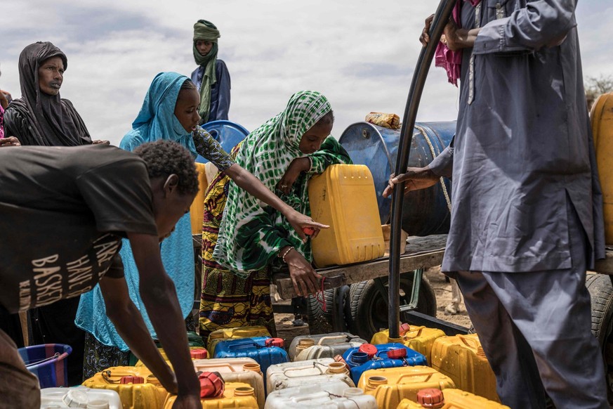 Un enfant montre du doigt un jerrican près d'un point d'eau dans un campement de fortune à Douéinkara, près de la frontière entre la Mauritanie et le Mali, le 29 avril 2026.