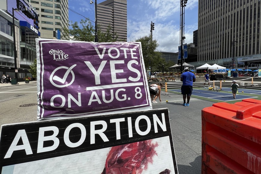 FILE - A sign asking Ohioans to vote in support of Issue 1 sits above another sign advocating against abortion rights at an event hosted by Created Equal on July 20, 2023, in Cincinnati, Ohio. Turnout ...