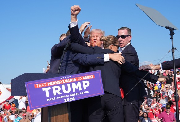 BUTLER, PENNSYLVANIA - July 13: Former president Donald Trump raises his arm with blood on his face during a campaign rally for former President Donald Trump at Butler Farm Show Inc. on Saturday, July ...