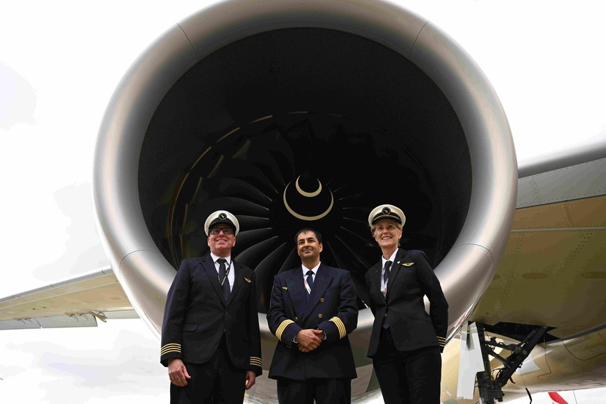 Les pilotes de Qantas posent pour une photo devant l'un des réacteurs de l'Airbus A350-1000ULR l'aéroport international de Melbourne.