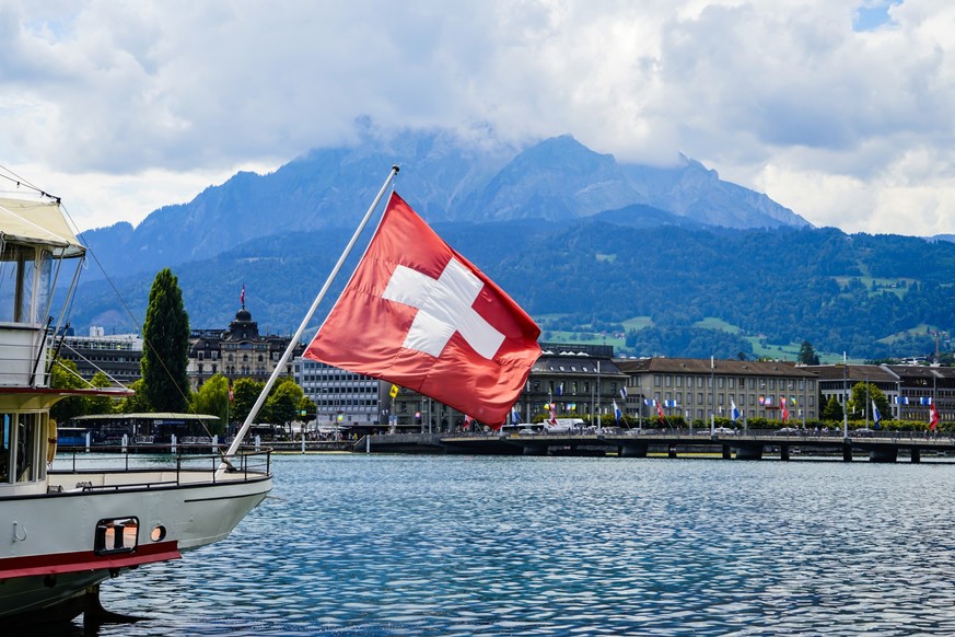 A view of a Swiss flag on a boat on lake Lucerne and Lucerne city in central Switzerland.
The surrounding mountains and hills are visible in the image. The mountain top is covered in clouds.
The mount ...