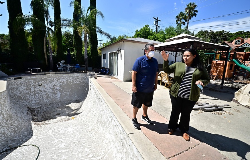 Priscilla Munoz and her husband Zack speak beside the now empty swimming pool at their home in Pasadena, California on August 22, 2025, which they had tested for toxic chemicals following the January  ...