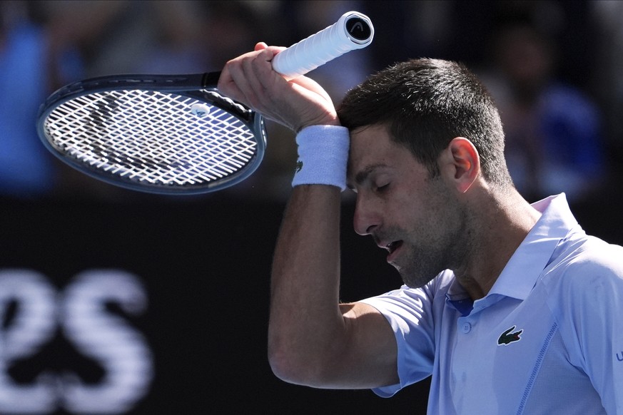 Novak Djokovic of Serbia wipes the sweat from his face during his semifinal against Jannik Sinner of Italy at the Australian Open tennis championships at Melbourne Park, Melbourne, Australia, Friday,  ...