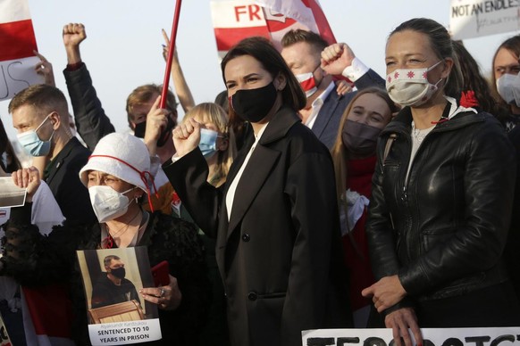 Belarus opposition leader Sviatlana Tsikhanouskaya, center, poses for photos with demonstrators during a protest demanding freedom for political prisoners, organized by a Belorussian cultural associat ...