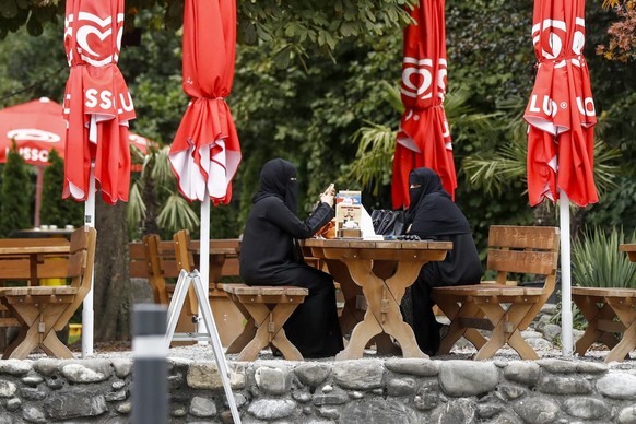 Asma, Touristin aus Riad, Saudi-Arabien, rechts, mit Niqab, und ihre Freundin sitzen in einem Restaurant, am Sonntag, 9. Oktober 2016, in Interlaken. (KEYSTONE/Peter Klaunzer)