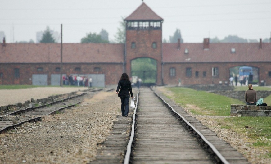 A young visitor walks on the railroad tracks at the Nazi death camp of Auschwitz-Birkenau, Poland, in this May 24, 2006, photo. UNESCO has officially renamed the site of the Auschwitz concentration ca ...