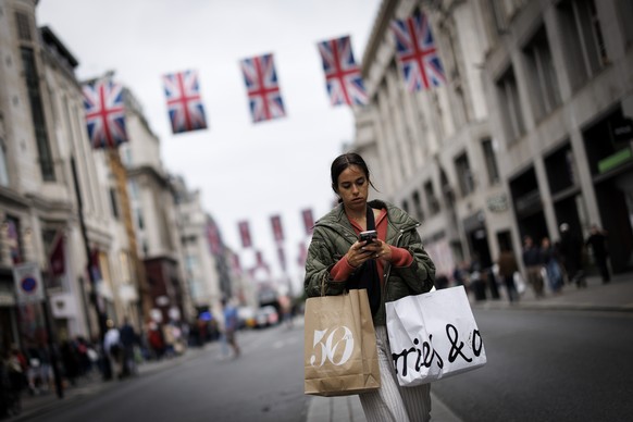 epa12102812 People carry shopping bags as they walk along Oxford Street in London, Britain, 15 May 2025. UK gross domestic product (GDP) rose by 0.7 percent between January and March, beating the earl ...