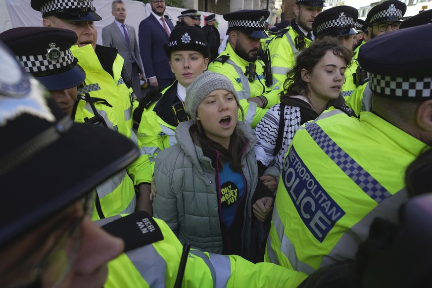 Environmental activist Greta Thunberg is taken away by police officers during the Oily Money Out protest outside the Intercontinental Hostel, in London, Tuesday, Oct. 17, 2023. (AP Photo/Kin Cheung)