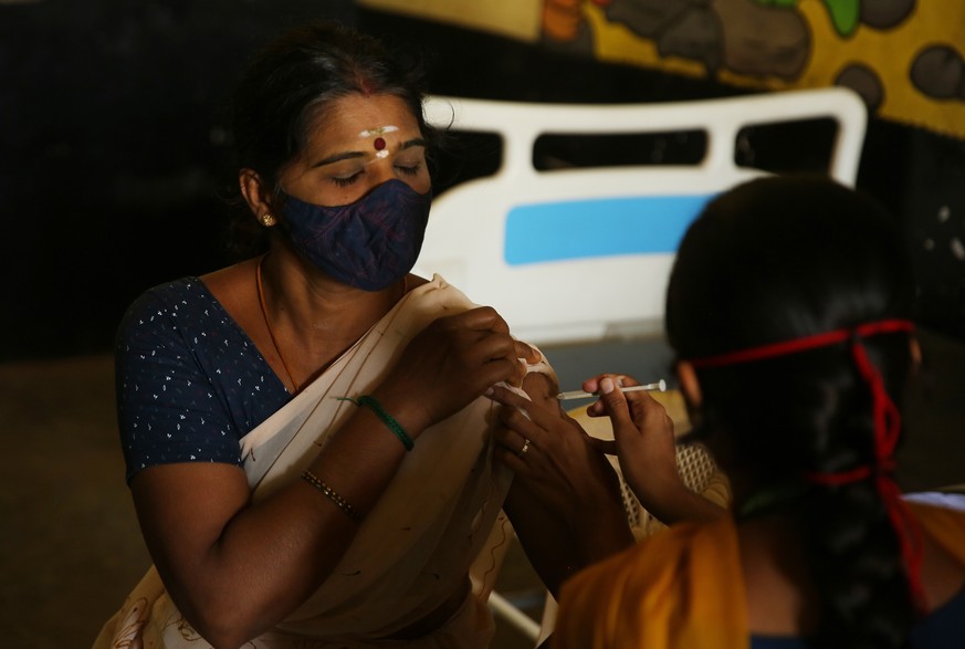 epa09255044 Indian woman receive a shot of COVID-19 vaccine during the vaccination drive in Bangalore, India, 08 June 2021. India reported 86,498 new Covid-19 cases and 2,115 coronavirus COVID19 death ...