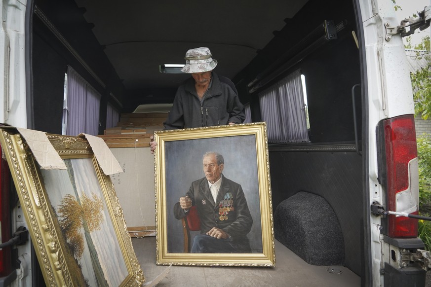 Well-known Kharkiv artist Oleksandr Kolesnyk holds a portrait of his father as he loads his 132 paintings to a minibus to evacuate them to a Kharkiv museum from his home village of Kotlovka close to V ...