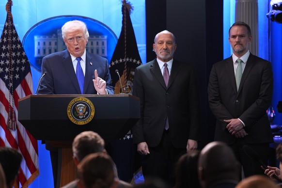 President Donald Trump speaks during a press briefing at the White House, Friday, Feb. 20, 2026, in Washington, as Commerce Secretary Howard Lutnick and Trade Representative Jamieson Greer, look on. ( ...