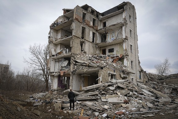 Local resident Yevhen, 34, looks at his home in an apartment house damaged in 2022 heavy battles with the Russian troops in Izium, Kharkiv region, Ukraine, Sunday, March 17, 2024. (AP Photo/Efrem Luka ...