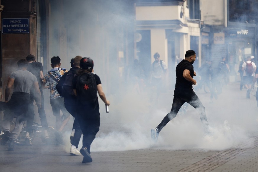 Youths run away during a protest Friday, June 30, 2023 in Strasbourg, eastern France. French President Emmanuel Macron urged parents Friday to keep teenagers at home and proposed restrictions on socia ...