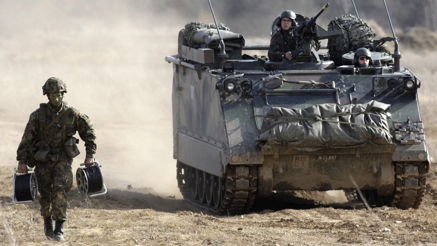 Un soldat court devant un char M113 dans le cadre de la premiere demonstration pratique DEMOEX de l&#039;armee Suisse, sur le theme de la defense mission premiere et traditionnelle de l&#039;armee, ce ...