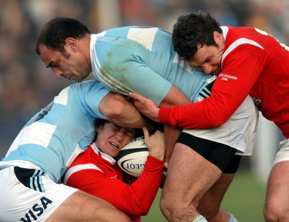 Alix Popham, center, of Wales, battles for the ball with Gonzalo Longo, top, of Argentina&#039;s Los Pumas, Sunday, June 11, 2006, during a test match in Puerto Madryn, 932.06 miles (1500 kilometers)  ...