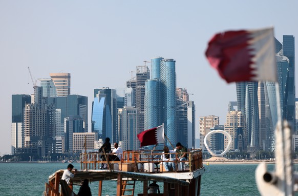 epa12783438 Qatari flags fly on boats backdropped by the skyline of Doha, Qatar, 28 February 2026. Qatar issued a national emergency alert following joint US-Israeli strikes on Iran. EPA/Hannibal Hans ...