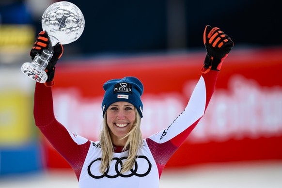Cornelia Huetter of Austria celebrates with the women&#039;s downhill overall leader crystal globe trophy in the finish area during the women&#039;s downhill race at the FIS Alpine Skiing World Cup fi ...