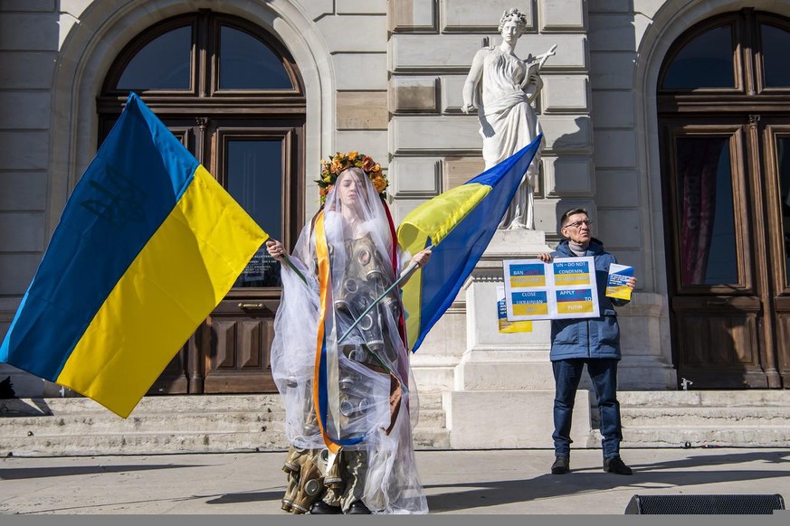 A protester wears a dress made from gas masks during a demonstration against the Russian invasion of Ukraine in Geneva, Switzerland, Saturday, March 05, 2022. Russian troops entered Ukraine on 24 Febr ...