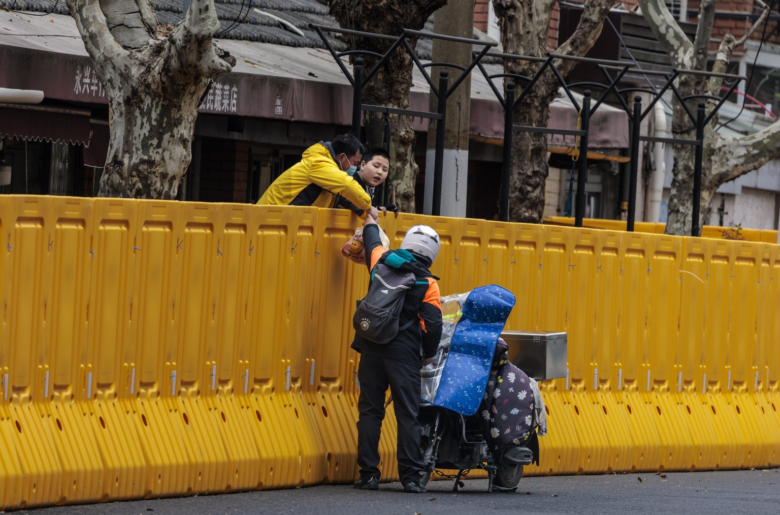 epa09861665 People receive food in the compound under quarantine amid the lockdown, in Puxi side of the city, in Shanghai, China, 31 March 2022. Shanghai city imposed a strict lockdown amid the COVID- ...