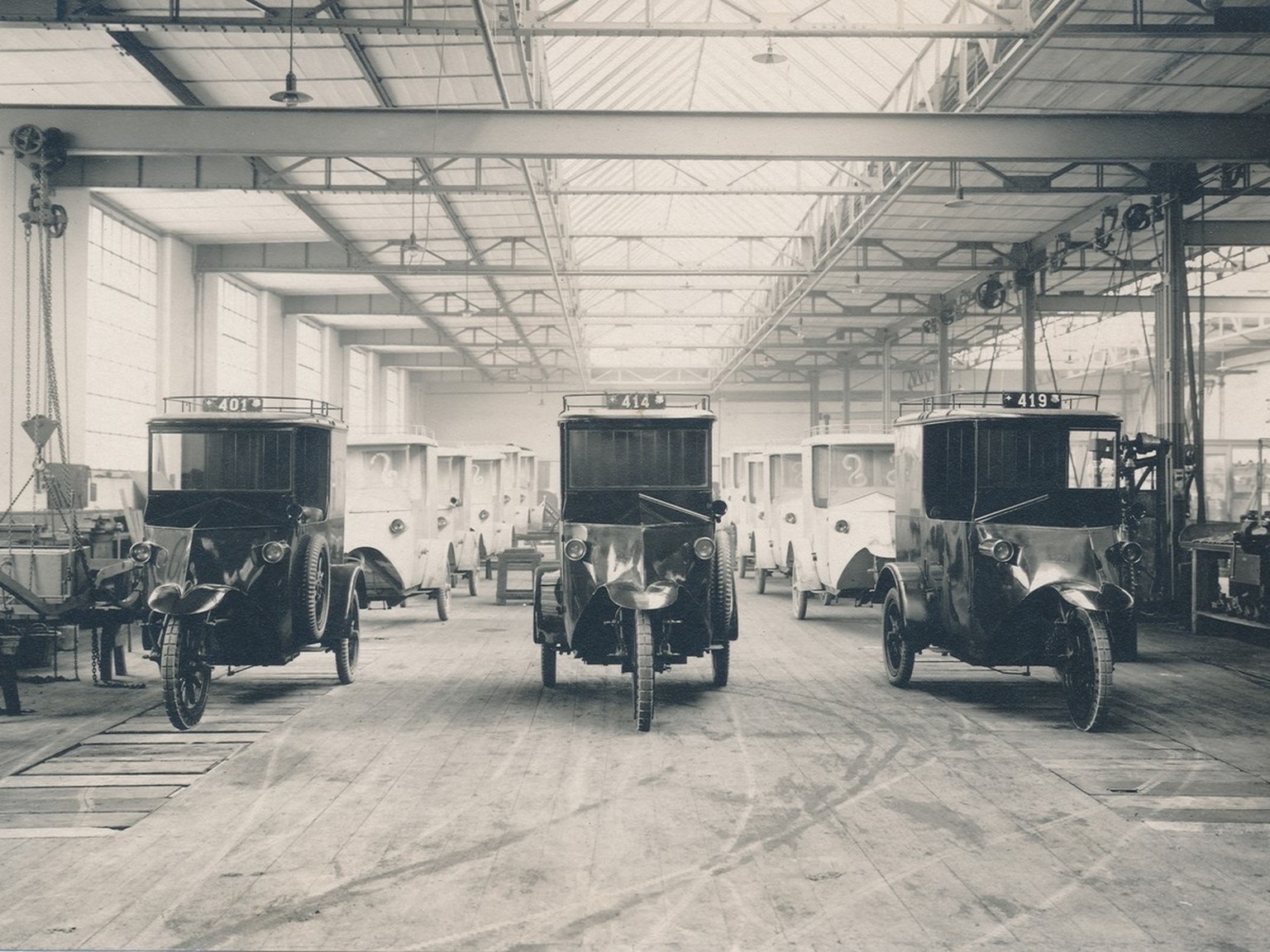 Rangées de tricycles électriques de La Poste, dans l’atelier de fabrication de l’entreprise Tribelhorn AG à Altstetten, vers 1920.