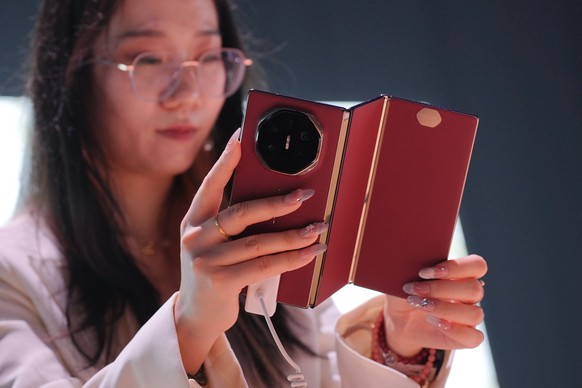 epa11904231 A Huawei staff hold a Mate XT tri-fold smartphone during a product launch event in Kuala Lumpur, Malaysia, 18 February 2025. Chinese tech giant Huawei unveiled the Huawei Mate XT, the worl ...
