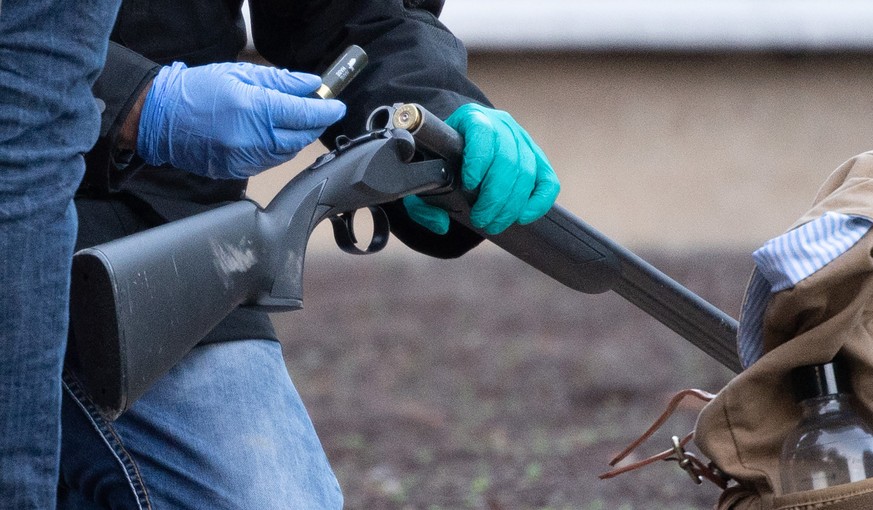 24.01.2022, Baden-W�rttemberg, Heidelberg: Polizeibeamte untersuchen eine Waffe am Gel�nde der Heidelberger Universit�t. Auf dem Campus der Heidelberger Universit�t hat es einen Amoklauf gegeben. Ein  ...