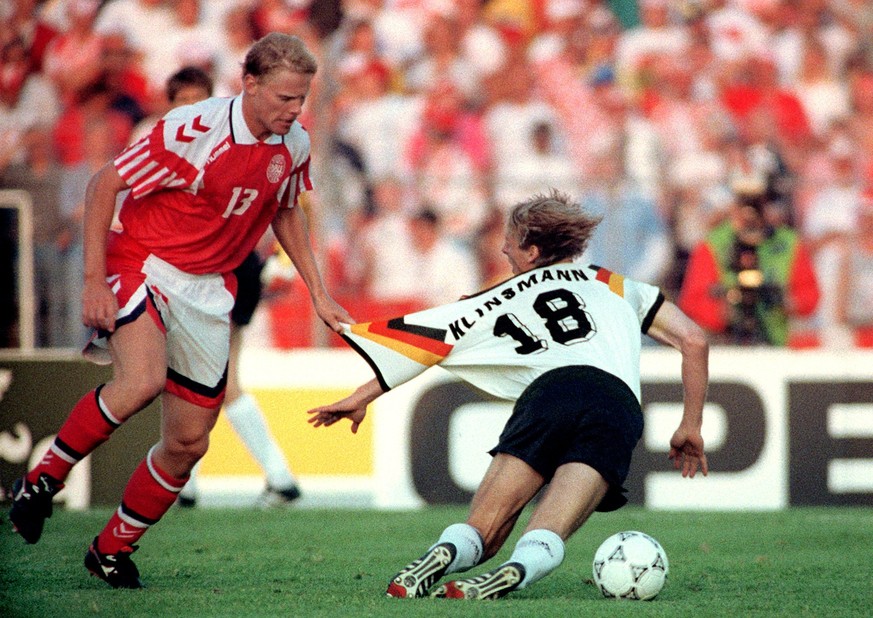 Der stuerzende deutsche Stuermer Juergen Klinsmann (rechts) wird vom daenischen Mittelfeldspieler Henrik Larsen am Trikot festgehalten. Die deutsche Fussballnationalmannschaft verliert als Weltmeister ...