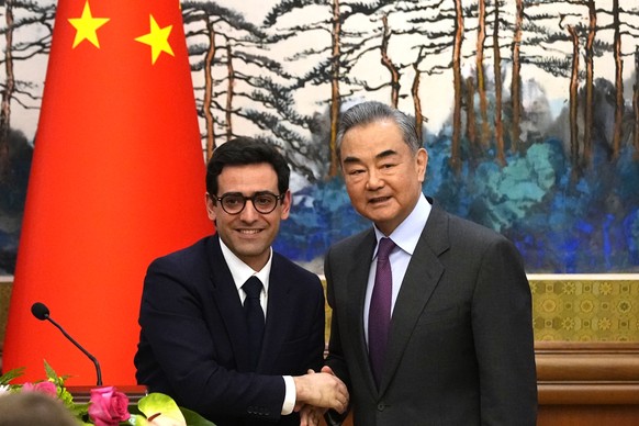 Chinese Foreign Minister Wang Yi, right, shakes hands with French Foreign Minister Stephane Sejourne, left, after a joint press conference at the Diaoyutai State Guesthouse in Beijing, China, Monday,  ...