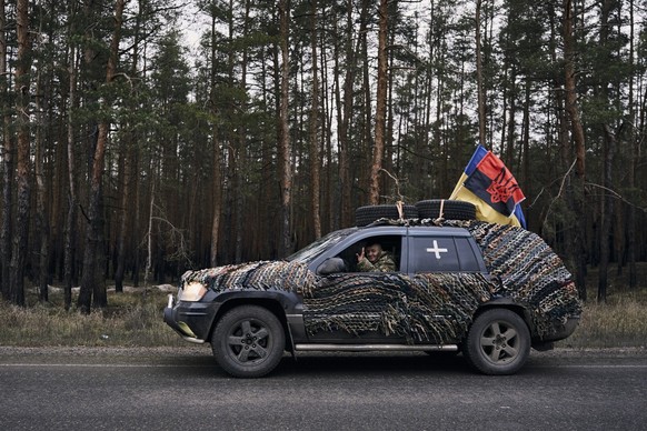 A Ukrainian army soldier waves from his car at the end of a wedding ceremony of two military medics in Lyman, Donetsk region, Ukraine, Saturday, Dec. 24, 2022. (AP Photo/Felipe Dana)