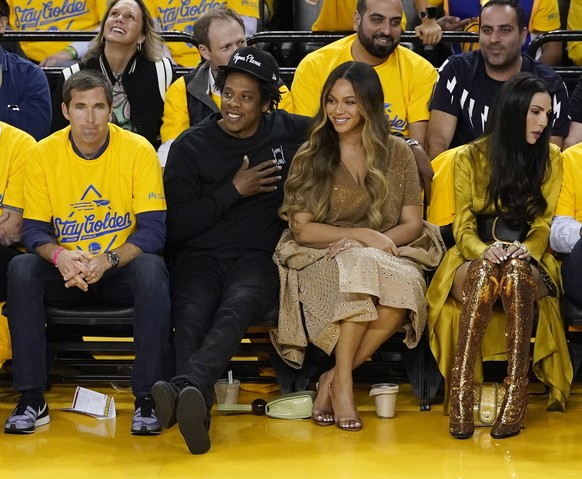 epa07628885 American singer Jay-Z (2-L, front) and his wife Beyonce (R) watch during the NBA Finals game three between the Toronto Raptors and the Golden State Warriors at Oracle Arena in Oakland, Cal ...