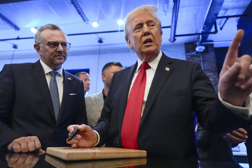 FILE - Republican presidential nominee former President Donald Trump signs autographs as Massad Boulos listens during a visit to The Great Commoner, Nov. 1, 2024, in Dearborn, Mich. (AP Photo/Julia De ...