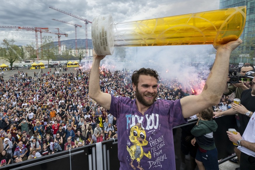 Le joueur du Geneve-Servette Hockey Club, Marc-Antoine Pouliot souleve la coupe et fete avec leurs supporters au lendemain de leur victoire du titre de champion de Suisse de hockey avec leurs fans a l ...