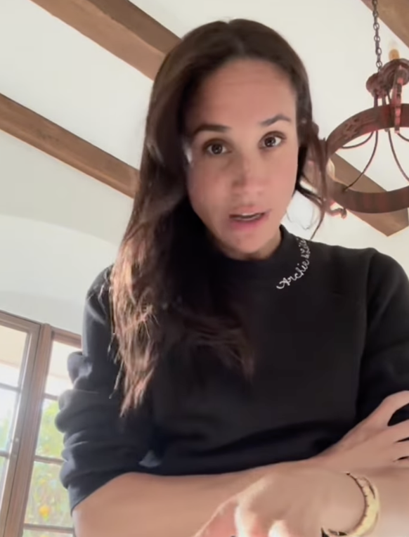 Et comme tout est dans les détails, Meghan portait un pull col rond noir Club Chainstitch, sur lequel sont brodés les prénoms «Archie &amp; Lili».