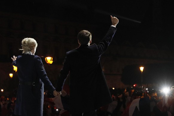 Incoming French President Emmanuel Macron and his wife Brigitte Macron wave at supporters in front of the Pyramid at the Louvre Museum in Paris, Sunday, May 7, 2017. Macron says that France is facing  ...