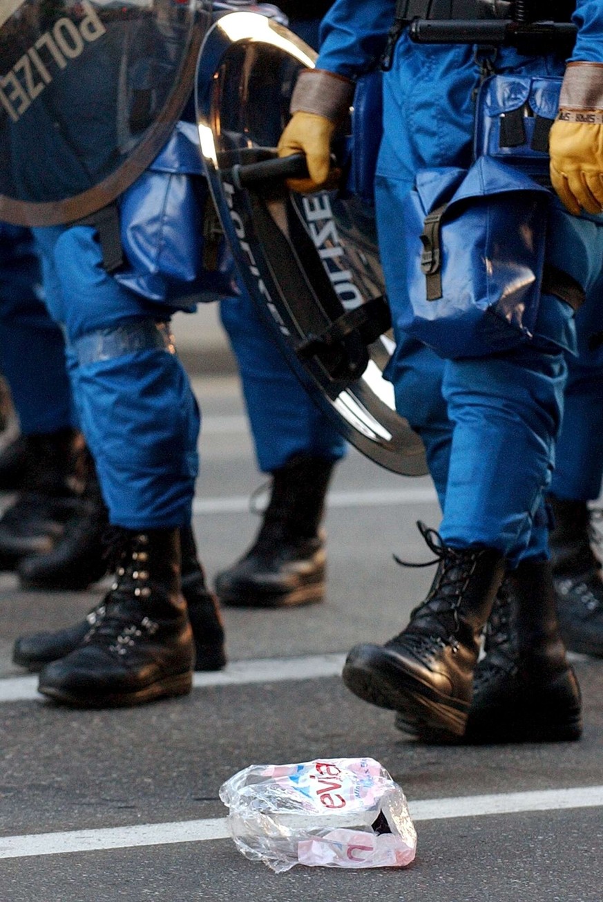 Zurich riot policers stand close to a packing of Evian water bottles, during clashes in Geneva, Switzerland, Monday, June 2, 2003. Police used tear gas and water cannons to disperse a group of protest ...