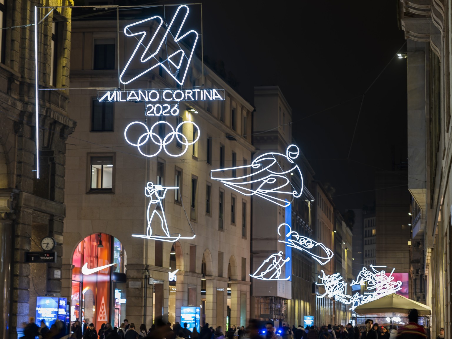 KEYPIX - People walk under Olympic illuminations representing winter sports along the Corso Vittorio Emanuele II, near Piazza Duomo ahead of the Milano Cortina 2026 Olympic Winter Games, in Milan, Ita ...