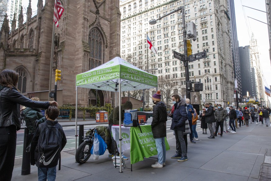 People line up for PCR and Rapid Antigen COVID-19 coronavirus tests on Wall Street in the Financial District in New York on Thursday, Dec. 16, 2021. The new omicron coronavirus mutant speeding around  ...
