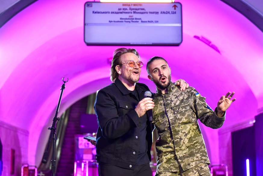 Le musicien irlandais Bono, à gauche, du groupe U2 se produit avec le chanteur ukrainien Taras Topolya, à droite, du groupe Antytila, soldat au sein de l'armée ukrainienne, dans la station de métro Khreshatyk à Kiev, en Ukraine.