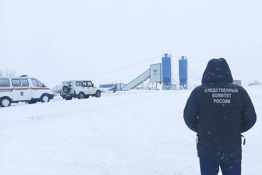 epa09602102 A handout photo made available by the Russian Investigative Committee (Sledcom) shows an investigator in front of the Listvyazhnaya coal mine near the town of Gramoteino in the Kemerovo re ...