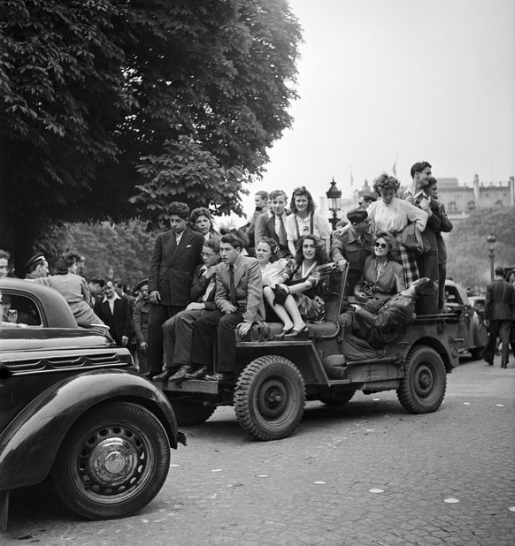 amerikanische Jeeps voll mit Menschen fahren durch Paris, fotografiert am 8. Mai 1945. AUS ORIGINALLEGENDE: &quot;Am Siegestag durchfuhren amerikanische Jeeps, beladen mit freudigen Sieges-Midinetten  ...