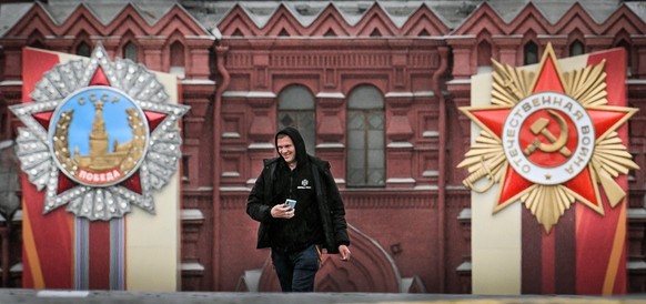 A man walks along Red Square decorated with banners to mark the 80th anniversary of the victory over Nazi Germany during World War II, in Moscow on May 4, 2025. (Photo by Alexander NEMENOV / AFP)
