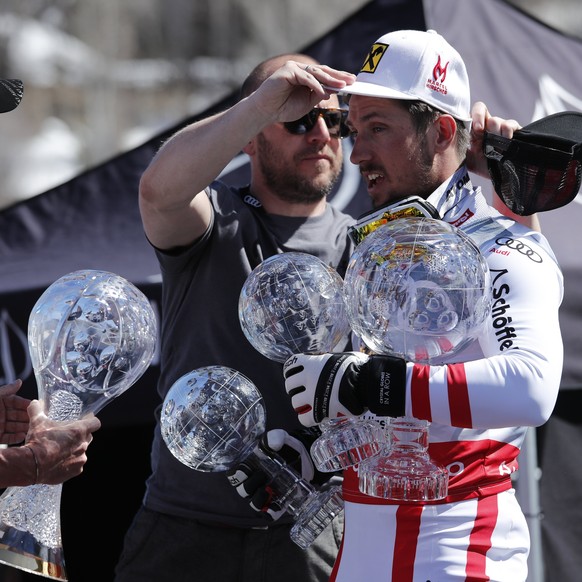 epa05858922 Marcel Hirscher of Austria (R) gets a hand carrying his 2017 Overall Crystal Globe and Globes in other events before a photo-op during the Audi FIS World Cup Finals in Aspen, Colorado, USA ...