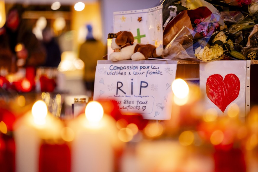 epa12626287 Flowers and candles are pictured in tribute to the victims after the fire at the 'Le Constellation' bar and lounge, in Crans-Montana, Switzerland, 04 January 2026. At least 40 pe ...