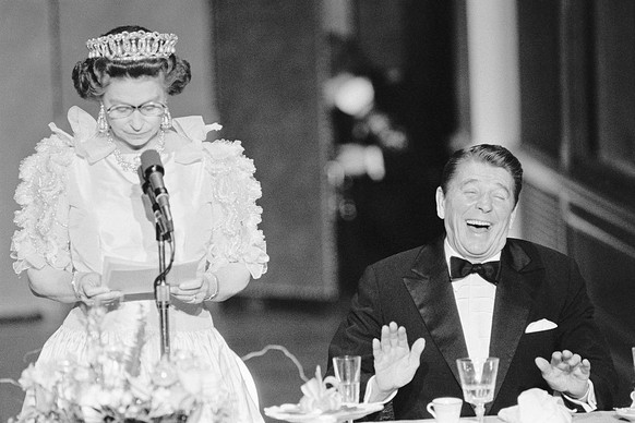 President Reagan laughs following a joke by Queen Elizabeth II, who commented on the lousy California weather she has experienced since her arrival to the States. The British Queen is delivering a bri ...