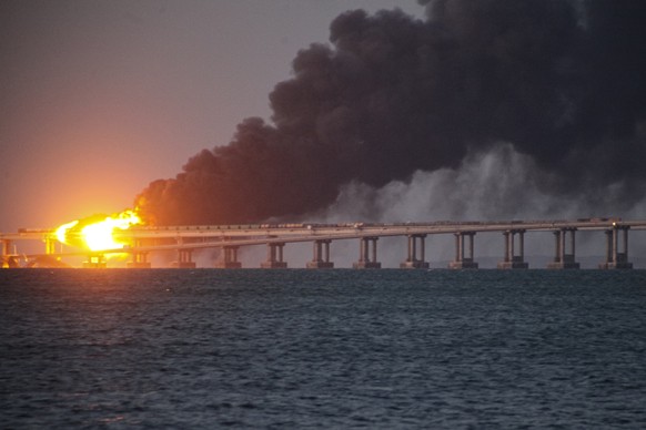 Flame and smoke rise fron Crimean Bridge connecting Russian mainland and Crimean peninsula over the Kerch Strait, in Kerch, Crimea, Saturday, Oct. 8, 2022. Russian authorities say a truck bomb has cau ...
