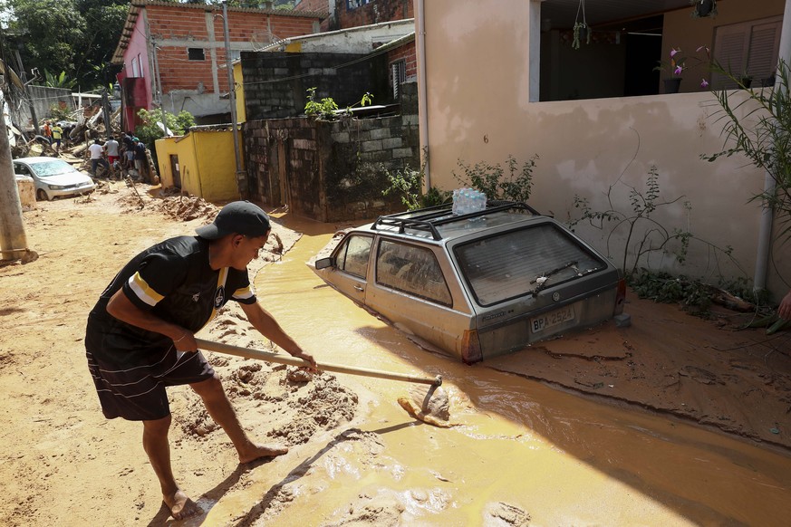 epa10482597 A man tries to rescue belongings after a landslide due to heavy rains in Sao Sebastiao, Sao Paulo state, Brazil, 21 February 2023. At least 44 people died due to heavy rains in Sao Paulo r ...