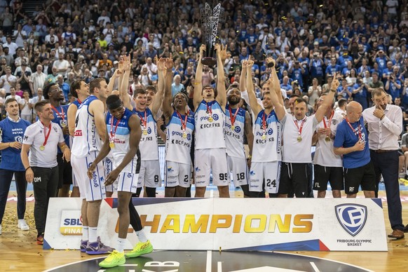 Die Spieler und Headcoach Petar Aleksic, rechts, verdrueckt eine Traene nach seinem Abschiedsspiel, waehrend seine Spieler mit dem Pokal des Basketball Schweizermeisters jubeln, nach dem 4. Swiss Bask ...