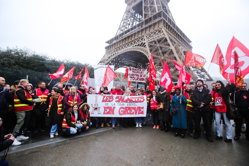 epa11171700 Striking workers carry a banner with the message &#039;Eiffel Tower employees on strike&#039; at the foot of the Eiffel Tower in Paris, France, 22 February 2024. The Eiffel Tower has been  ...